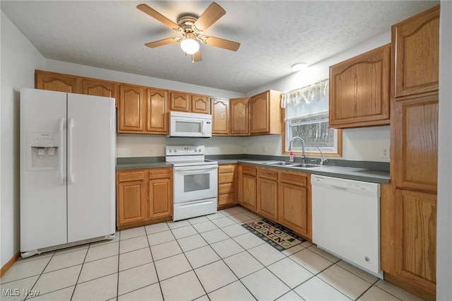 kitchen with white appliances, sink, ceiling fan, light tile patterned floors, and a textured ceiling