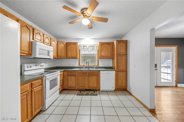 kitchen featuring light tile patterned floors, white appliances, ceiling fan, and sink