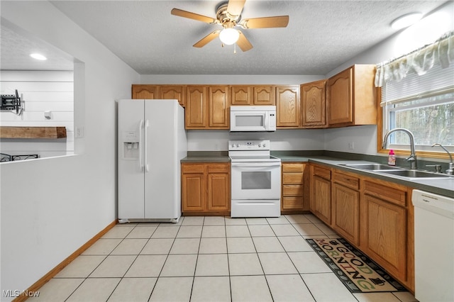 kitchen with ceiling fan, sink, a textured ceiling, white appliances, and light tile patterned floors