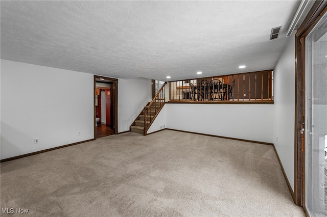 interior space with light colored carpet and a textured ceiling