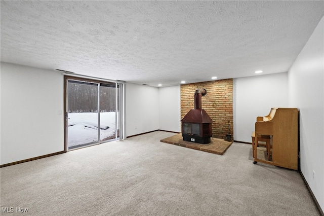 interior space with a textured ceiling and a wood stove