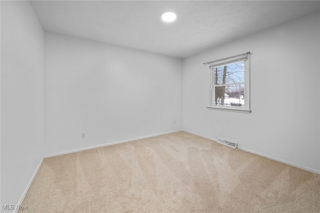 unfurnished room featuring light carpet