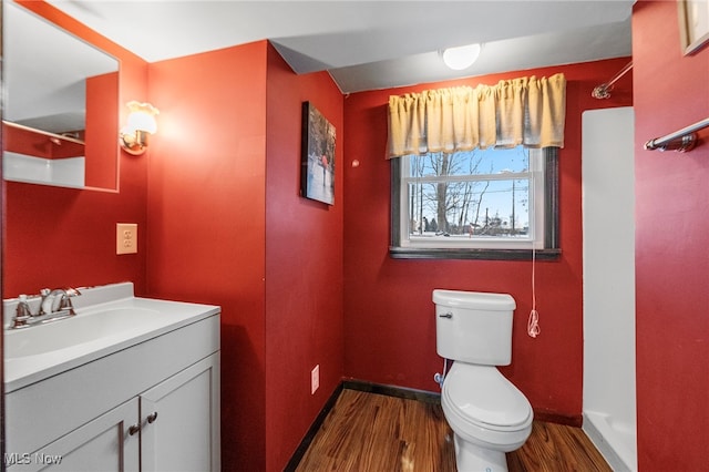 bathroom with a shower, vanity, wood-type flooring, and toilet