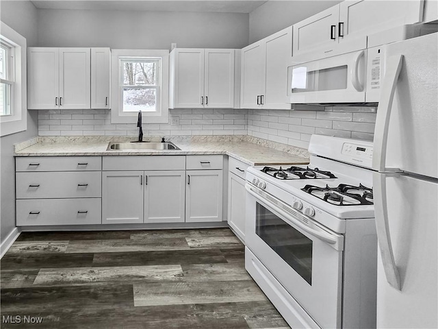 kitchen featuring white cabinetry, sink, tasteful backsplash, dark hardwood / wood-style floors, and white appliances