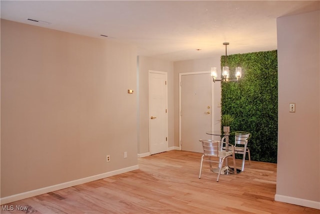 spare room with a chandelier and wood-type flooring