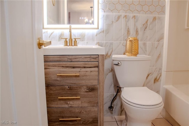 bathroom featuring tile patterned flooring, vanity, toilet, and tile walls