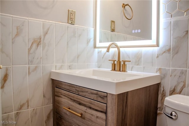 bathroom featuring vanity, toilet, tile walls, and backsplash