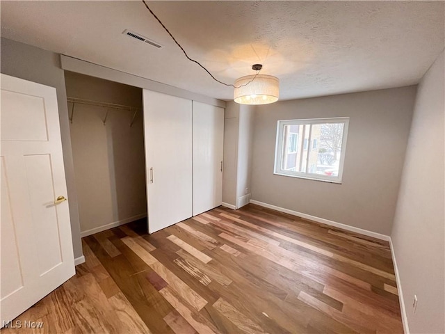 unfurnished bedroom featuring a textured ceiling and hardwood / wood-style flooring