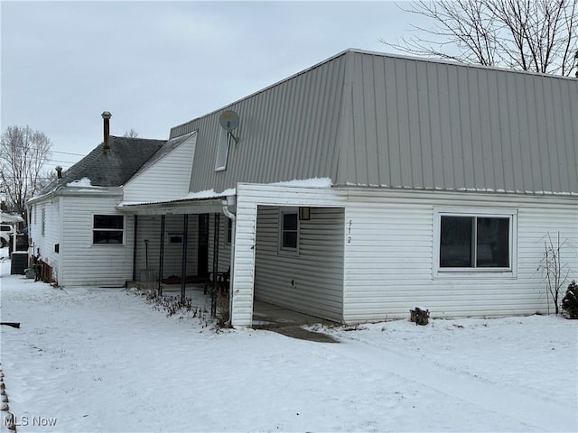 view of snow covered rear of property