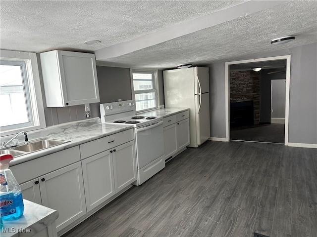 kitchen featuring white appliances, white cabinets, sink, dark hardwood / wood-style flooring, and light stone counters