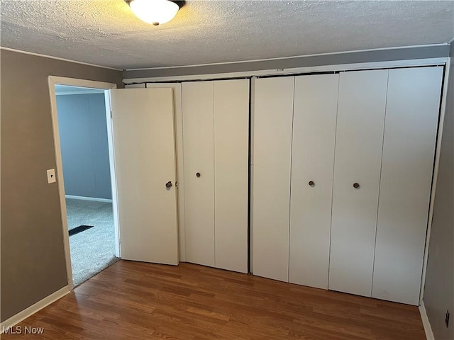 unfurnished bedroom with a textured ceiling and hardwood / wood-style flooring