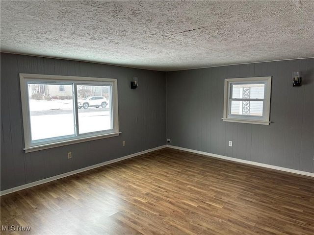 spare room featuring hardwood / wood-style flooring and a textured ceiling