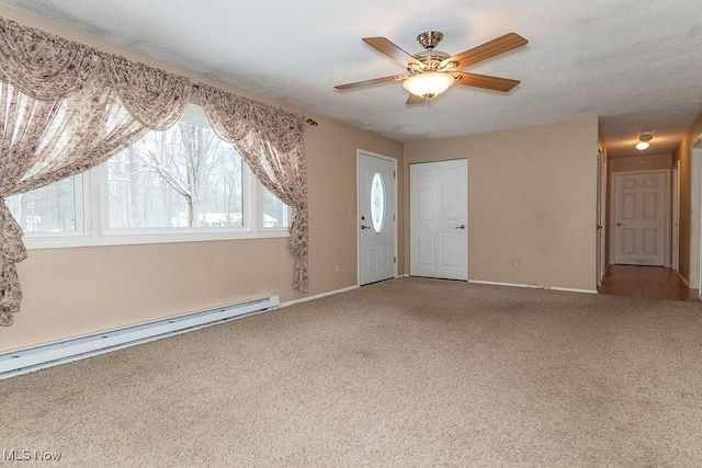 carpeted empty room featuring ceiling fan and a baseboard heating unit