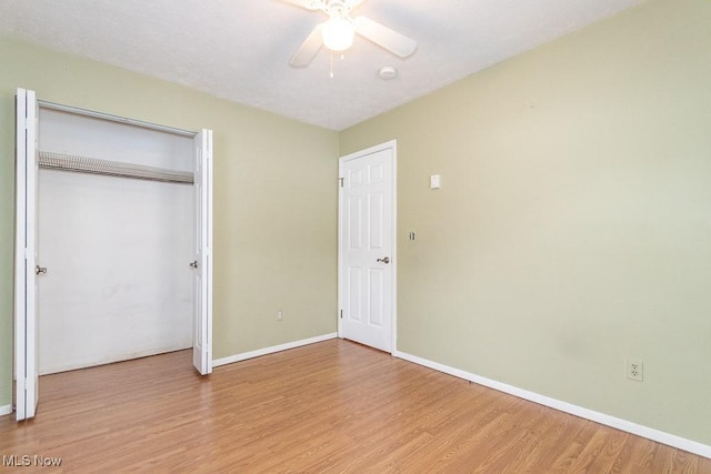 unfurnished bedroom featuring ceiling fan, light hardwood / wood-style floors, and a closet