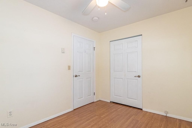 unfurnished bedroom featuring a closet, light hardwood / wood-style floors, and ceiling fan