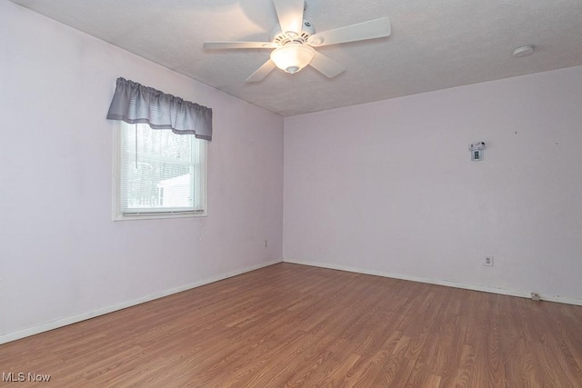 spare room featuring wood-type flooring and ceiling fan