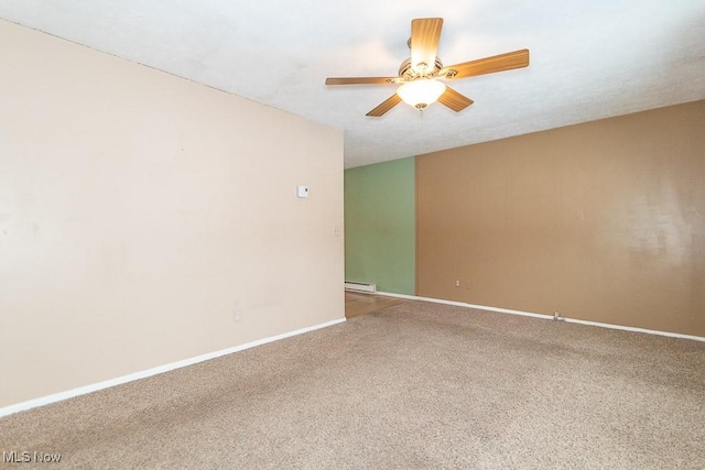 spare room with carpet, ceiling fan, and a baseboard heating unit