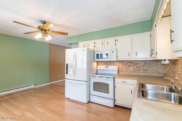 kitchen with decorative backsplash, white appliances, a baseboard heating unit, sink, and white cabinetry