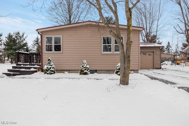 view of snow covered exterior featuring a garage