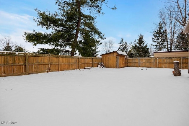 snowy yard featuring a storage unit