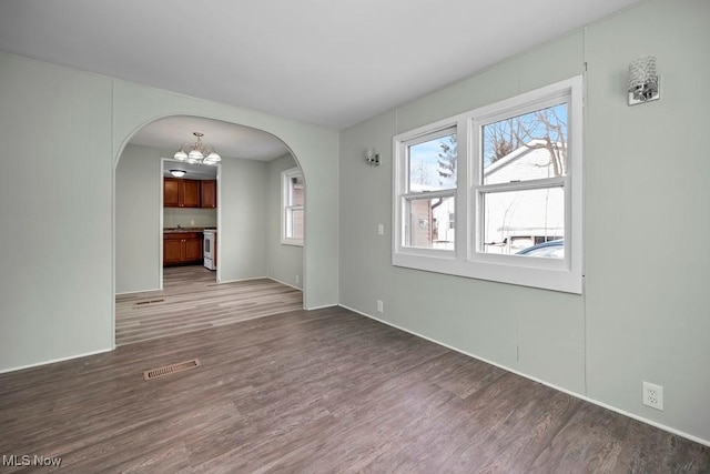 empty room with a chandelier and hardwood / wood-style floors