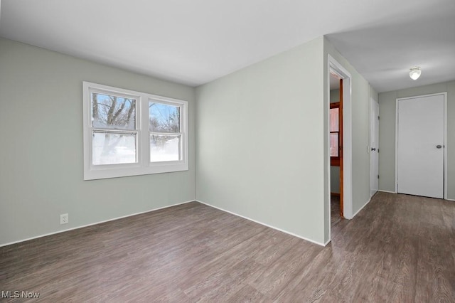 unfurnished room featuring dark wood-type flooring