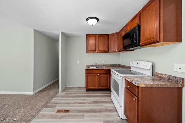 kitchen with electric range, light hardwood / wood-style floors, and sink