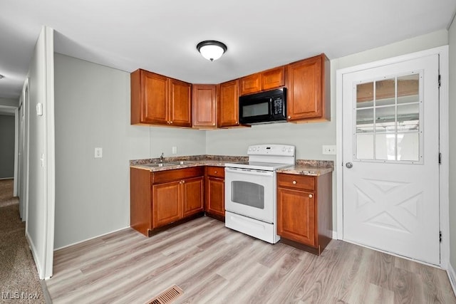 kitchen featuring light wood-type flooring, white electric range, and sink