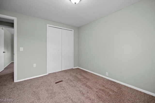 unfurnished bedroom with carpet floors and a closet