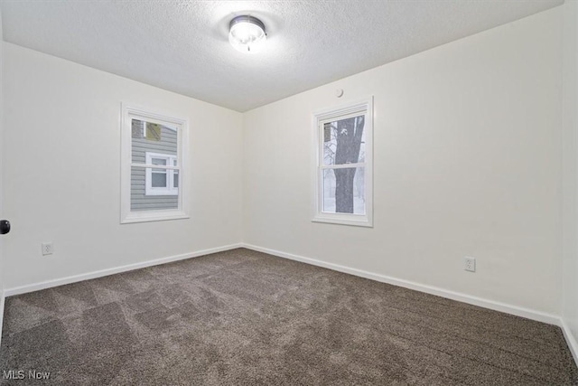 carpeted spare room with a textured ceiling