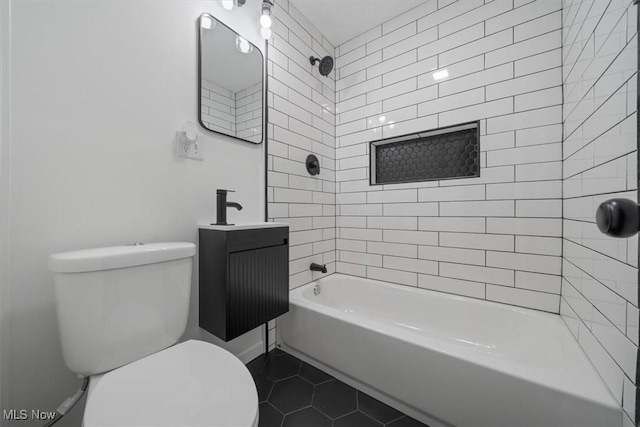 full bathroom featuring tile patterned flooring, vanity, tiled shower / bath combo, and toilet