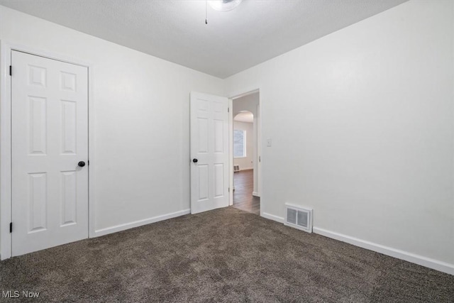 empty room with dark carpet