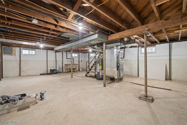 basement with heating unit, electric panel, and gas water heater