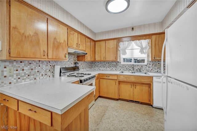 kitchen featuring white appliances, tasteful backsplash, and sink