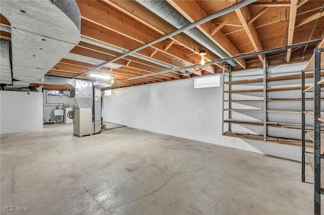 basement with washer and dryer, heating unit, and a wealth of natural light