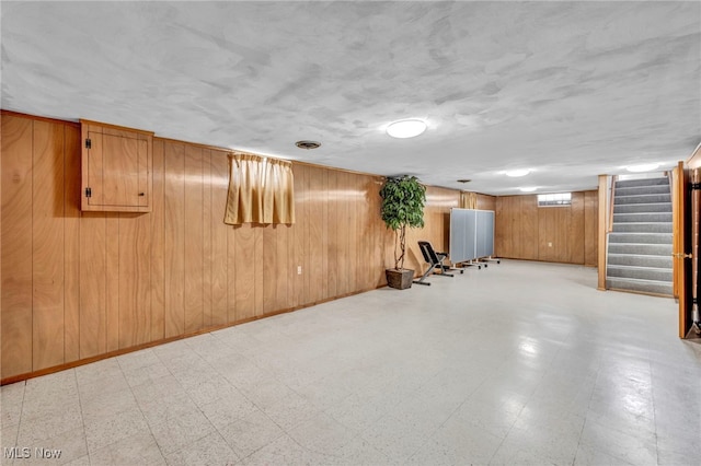 basement featuring wooden walls