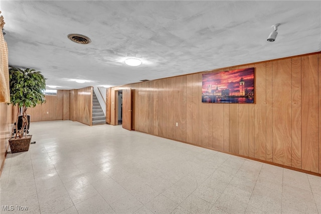 basement featuring wood walls