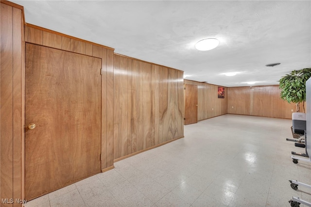 hallway featuring wood walls