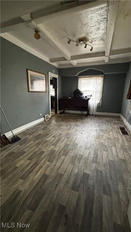 interior space with beam ceiling, a textured ceiling, and hardwood / wood-style flooring