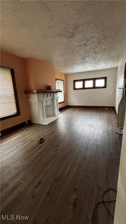 unfurnished living room with hardwood / wood-style flooring and a textured ceiling