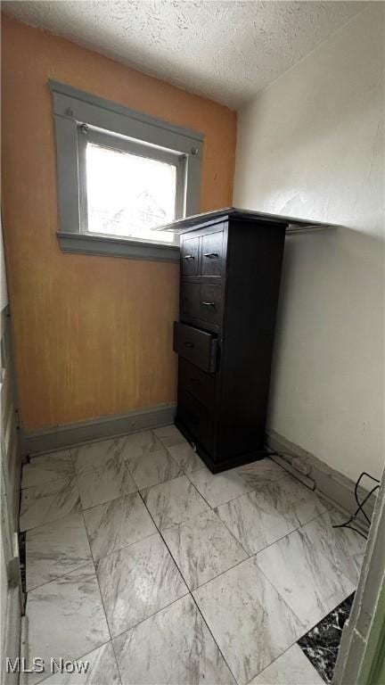 laundry area with a textured ceiling