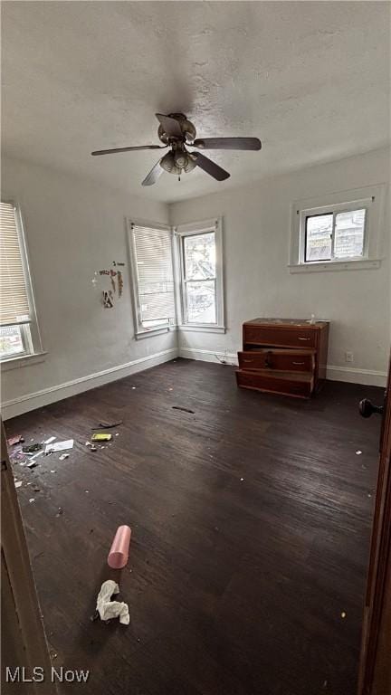 interior space featuring dark hardwood / wood-style flooring, ceiling fan, and a healthy amount of sunlight