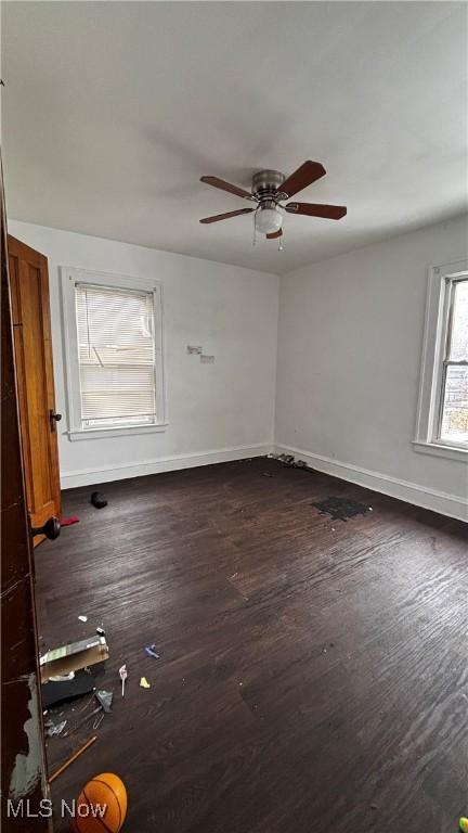 empty room featuring ceiling fan and dark wood-type flooring