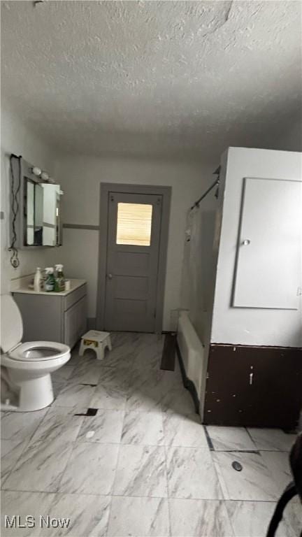 bathroom with a shower with shower curtain, a textured ceiling, and toilet