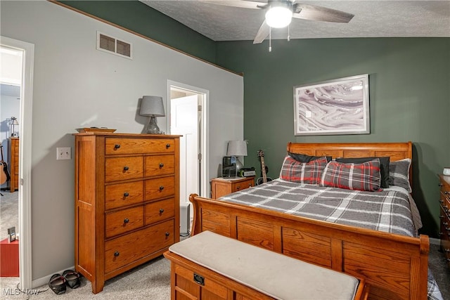 bedroom featuring lofted ceiling, ceiling fan, light colored carpet, and a textured ceiling