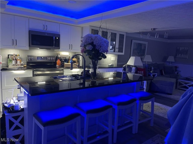 interior space with decorative backsplash, sink, white cabinetry, and stainless steel appliances