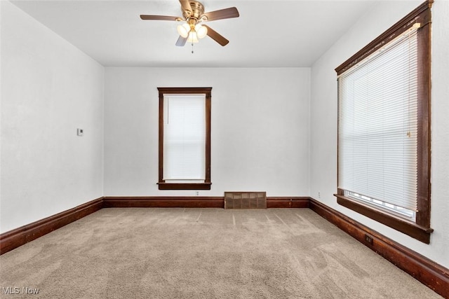 carpeted spare room featuring ceiling fan