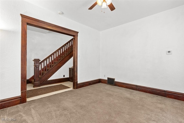 carpeted spare room featuring ceiling fan