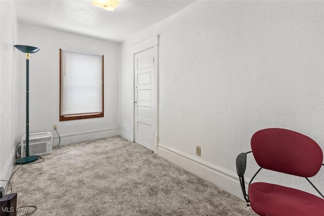 empty room featuring light colored carpet and a wall mounted AC