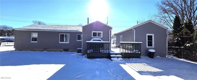 snow covered property with central AC unit and a deck